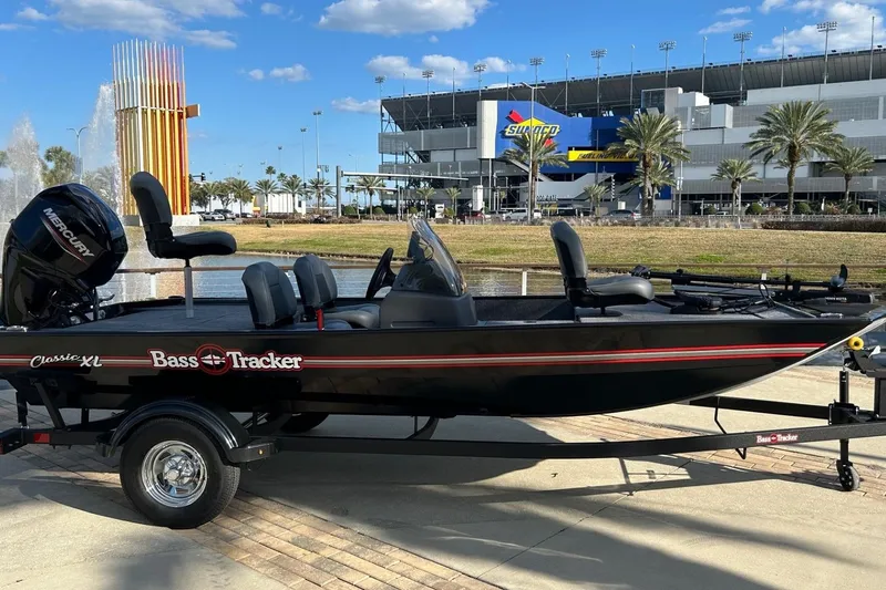 Slide: The Image of 2026 Tracker Bass Tracker Classic XL boat parked near a stadium with palm trees. - 2