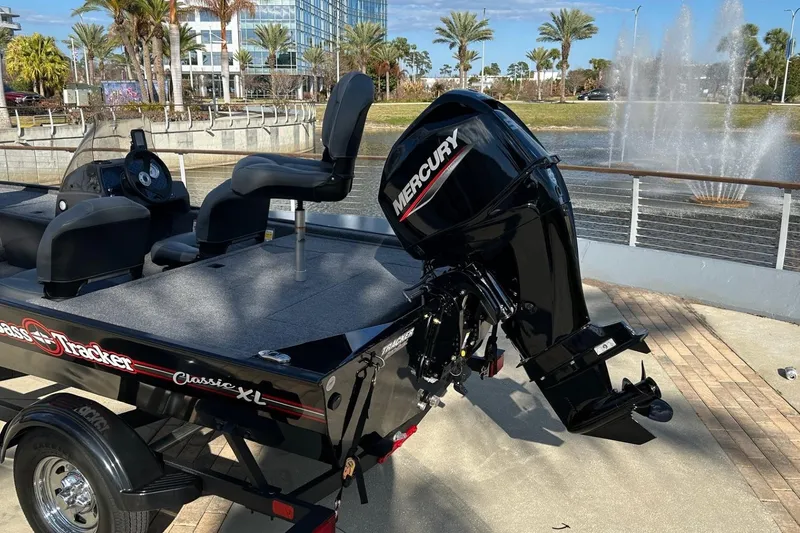 Slide: The Image of 2026 Tracker Bass Tracker Classic XL boat with Mercury engine by a fountain. - 9