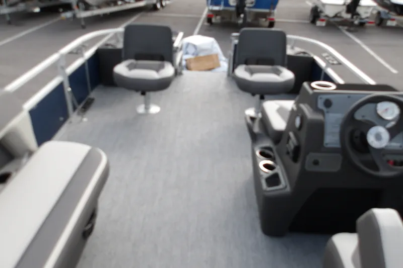Slide: The Image of 2026 Sun Tracker Bass Buggy 18 DLX pontoon boat interior with seating and console. - 18