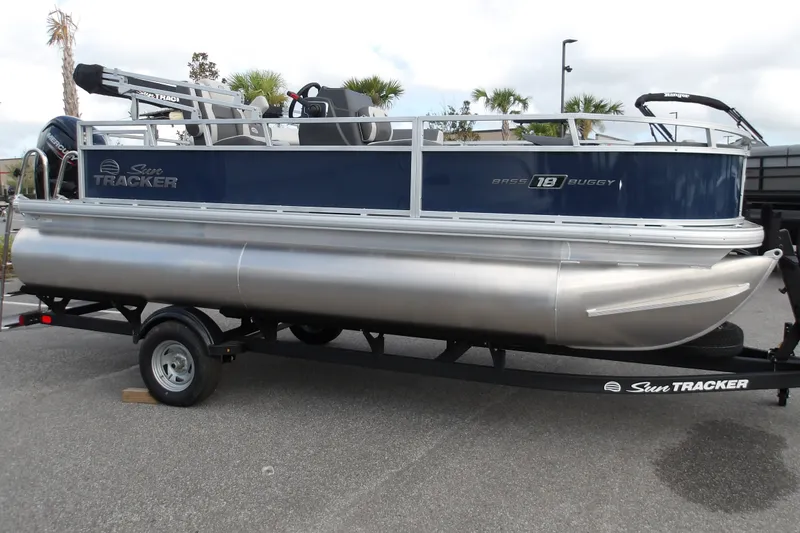 The Image of 2026 Sun Tracker Bass Buggy 18 DLX pontoon boat on trailer, parked outdoors. - 1