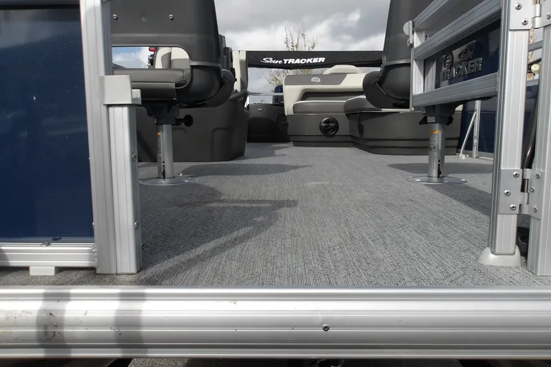 Slide: The Image of 2026 Sun Tracker Bass Buggy 18 DLX pontoon boat interior with seating and carpeted deck. - 25