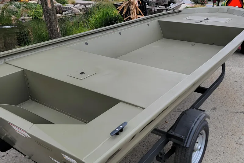 The Image of 2026 Tracker Grizzly 1648 Utility boat on trailer, parked outdoors. - 0