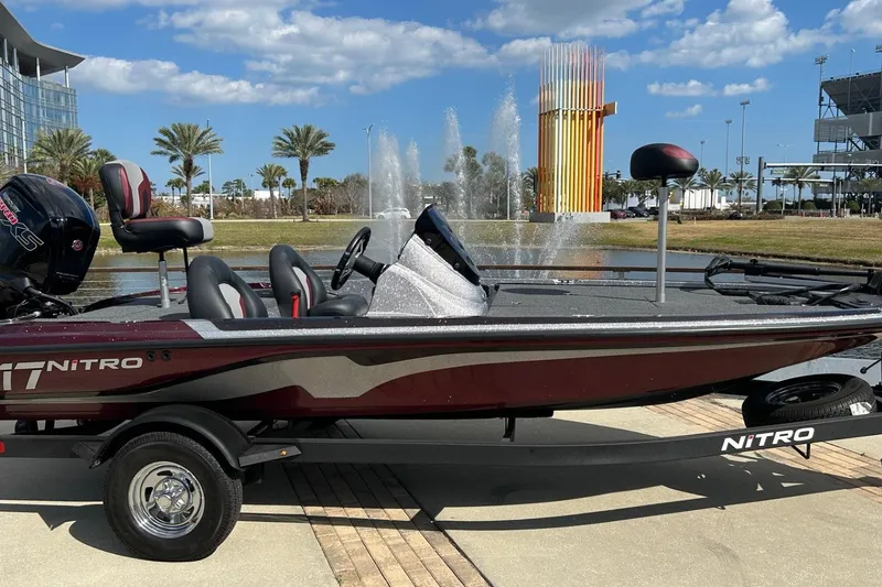 Slide: The Image of 2025 Nitro Z17 boat parked near a fountain with palm trees in the background. - 2