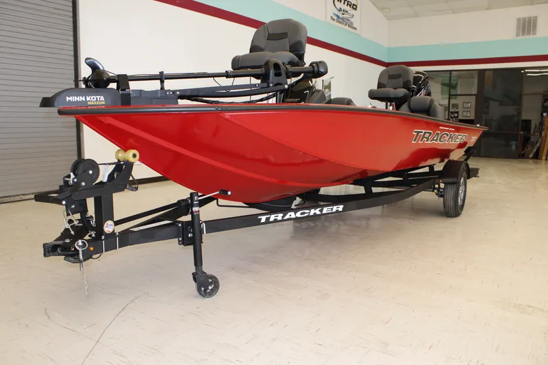 Slide: The Image of 2026 Tracker Pro Team 190 boat in showroom, featuring red hull and Minn Kota trolling motor. - 2