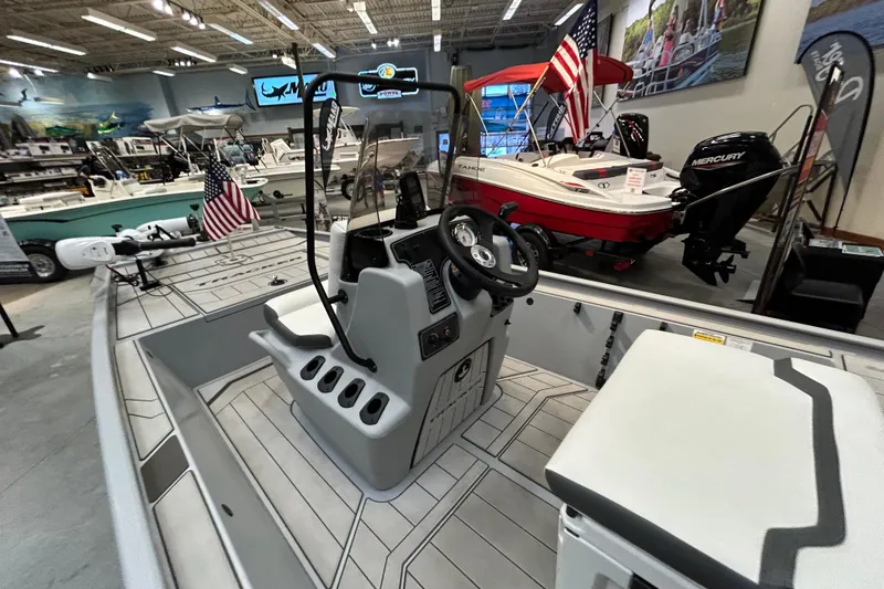 Slide: The Image of 2026 Tracker Bass Tracker Classic CC boat interior in showroom with American flag display. - 5