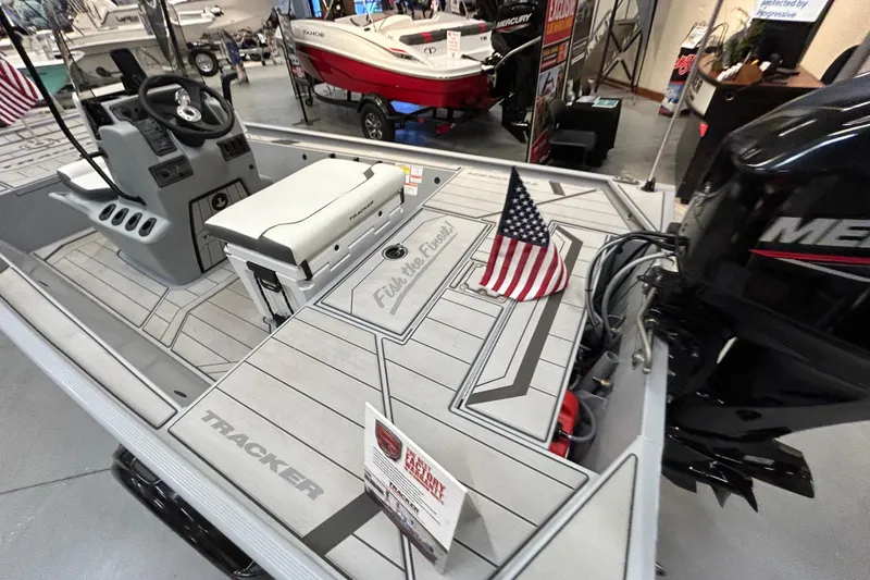 Slide: The Image of 2026 Tracker Bass Tracker Classic CC boat interior with American flag and Mercury engine. - 4