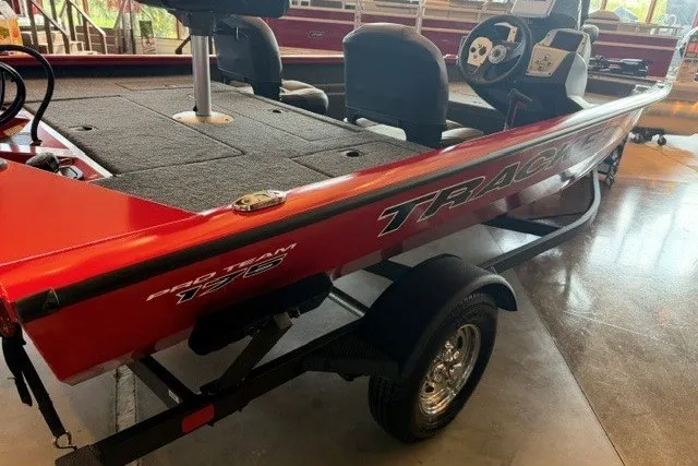 The Image of 2026 Tracker Pro Team 175 Crappie Edition boat, red exterior, displayed indoors. - 0