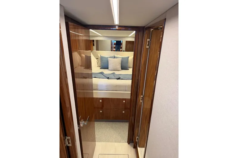 Slide: The Image of Luxurious bedroom interior of 2025 Riviera 50 Sports Motor Yacht with elegant wood finish. - 10