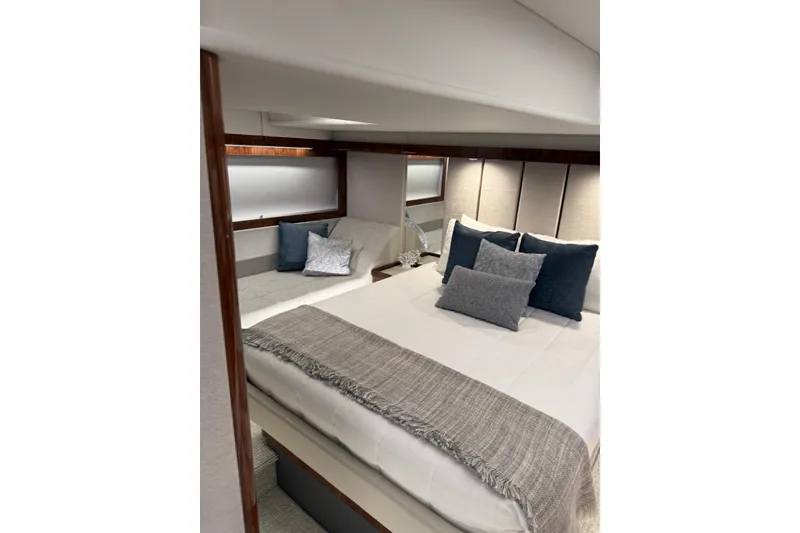 Slide: The Image of Luxurious bedroom interior of 2025 Riviera 50 Sports Motor Yacht with elegant bedding. - 12