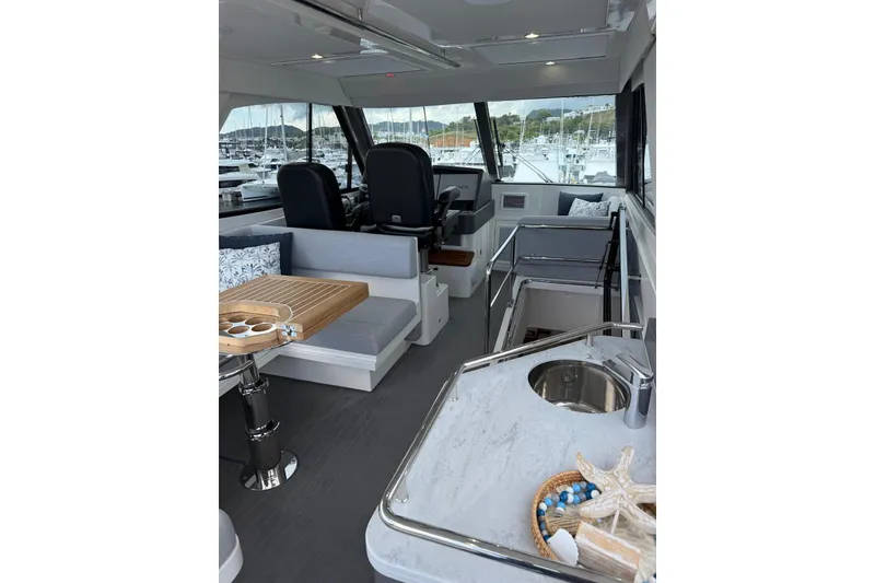Slide: The Image of Interior of 2025 Riviera 50 Sports Motor Yacht with modern seating and helm. - 16
