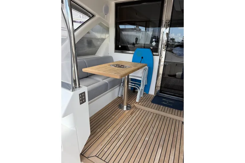 Slide: The Image of 2025 Riviera 50 Sports Motor Yacht interior with wooden deck and seating area. - 4