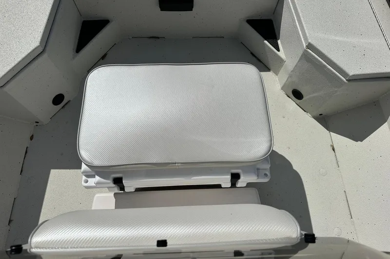 Slide: The Image of 2025 Ranger RB210 boat interior with white cushioned seating and storage compartments. - 12