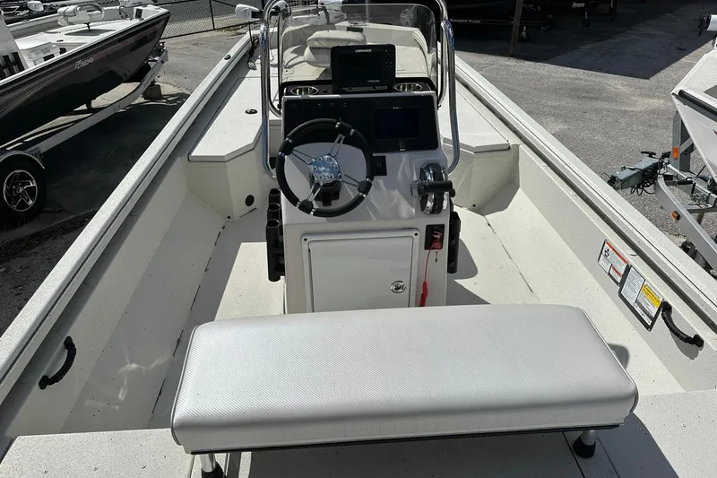 Slide: The Image of 2025 Ranger RB210 boat interior with steering console and seating, parked outdoors. - 13