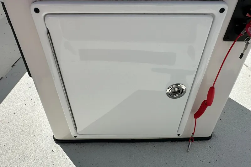 Slide: The Image of White storage compartment on 2025 Ranger RB210 boat with red safety lanyard. - 17