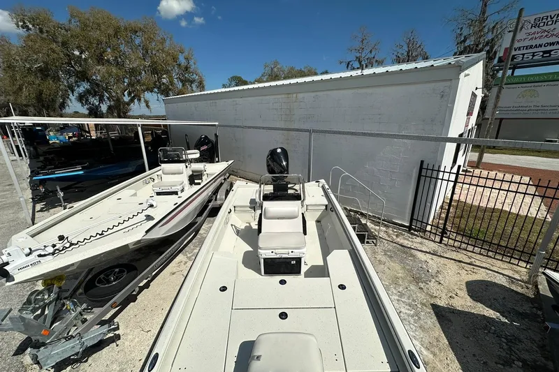 Slide: The Image of 2025 Ranger RB210 boat parked outdoors near a white building under a clear blue sky. - 5