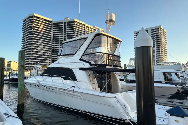 The Image of 1998 Sea Ray 480 Sedan Bridge yacht docked at marina with high-rise buildings in background. - 0