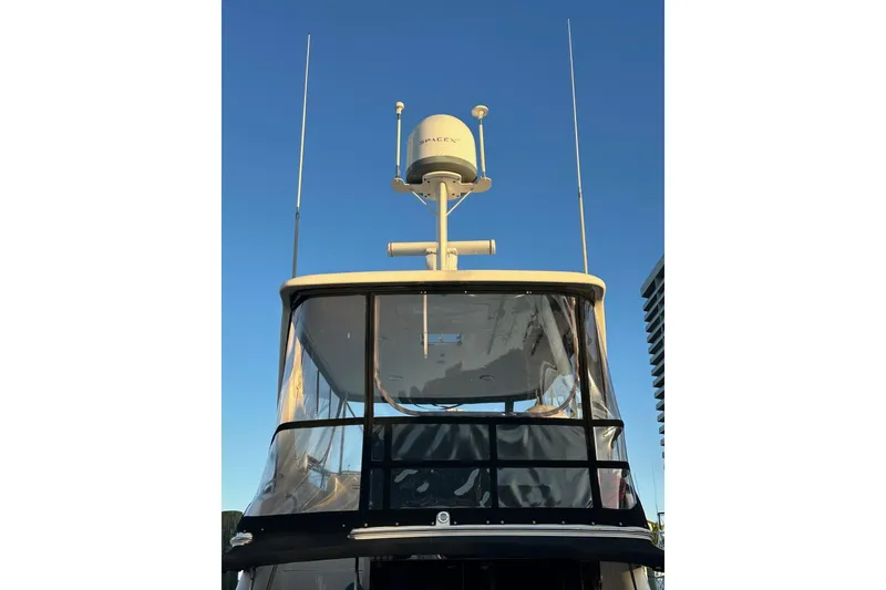 Slide: The Image of 1998 Sea Ray 480 Sedan Bridge yacht with radar and antennas against clear sky. - 11