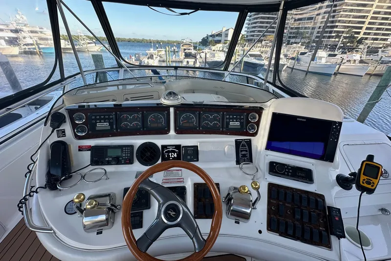 Slide: The Image of 1998 Sea Ray 480 Sedan Bridge helm with navigation instruments and marina view. - 15