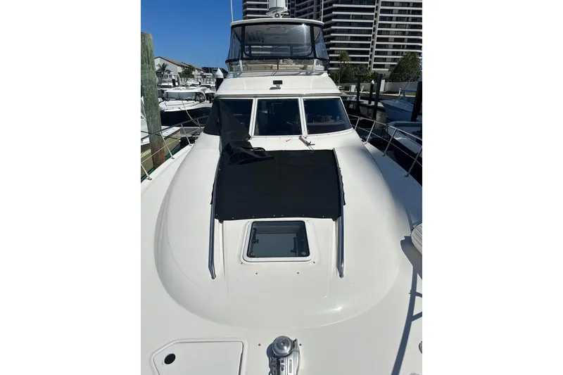 Slide: The Image of 1998 Sea Ray 480 Sedan Bridge yacht docked at marina, showcasing sleek design and spacious deck. - 23