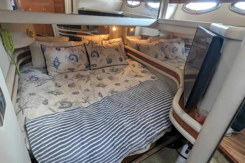 Slide: The Image of Cozy bedroom interior of 1998 Sea Ray 480 Sedan Bridge yacht with nautical-themed bedding. - 29