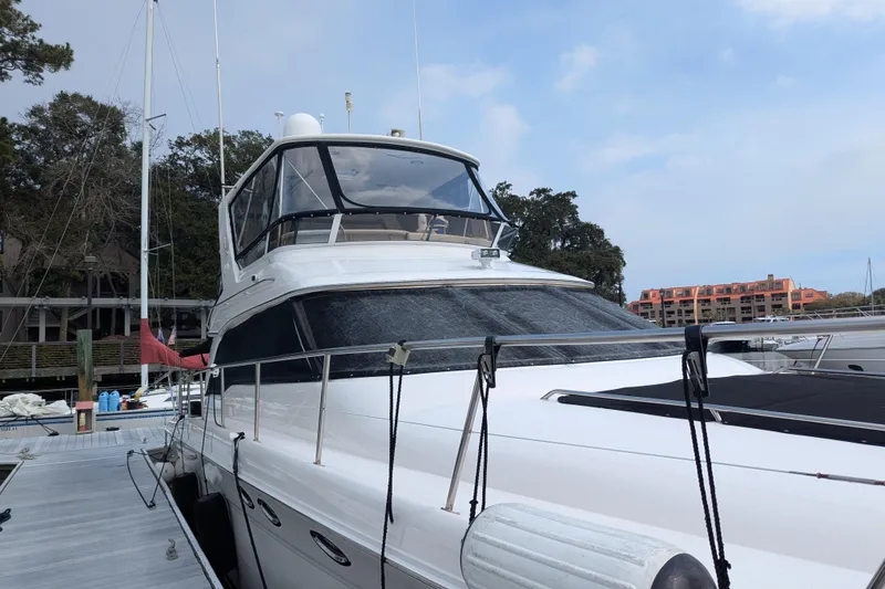 Slide: The Image of 1998 Sea Ray 480 Sedan Bridge yacht docked at marina, clear sky background. - 3