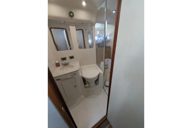 Slide: The Image of Bathroom interior of 1998 Sea Ray 480 Sedan Bridge yacht, featuring sink and toilet. - 33