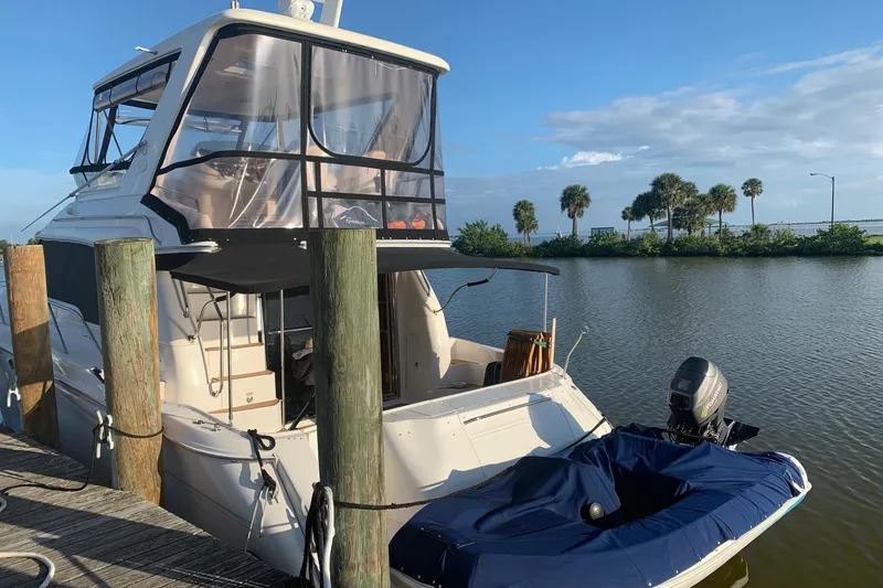 Slide: The Image of 1998 Sea Ray 480 Sedan Bridge yacht docked by a scenic waterfront. - 6