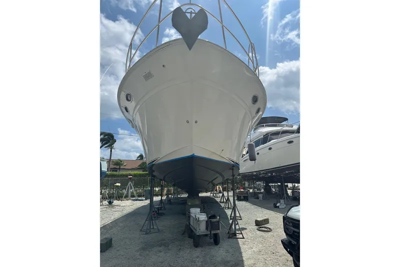 Slide: The Image of 1998 Sea Ray 480 Sedan Bridge yacht on dry dock under a clear sky. - 9