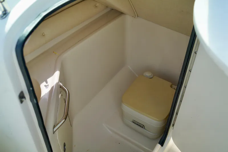 Slide: The Image of 2005 Sea Ray 240 Bow Rider interior with compact marine toilet. - 12