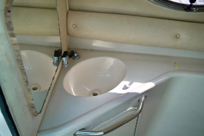 Slide: The Image of 2005 Sea Ray 240 Bow Rider bathroom sink with mirror and chrome fixtures. - 15