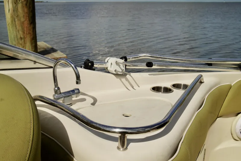 Slide: The Image of 2005 Sea Ray 240 Bow Rider interior with sink and cup holders by the water. - 17