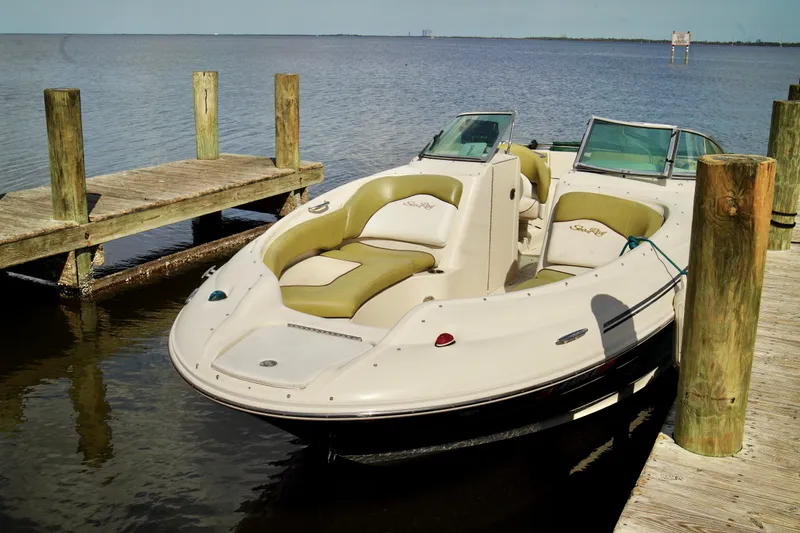 Slide: The Image of 2005 Sea Ray 240 Bow Rider docked on calm water, showcasing sleek design and comfortable seating. - 2