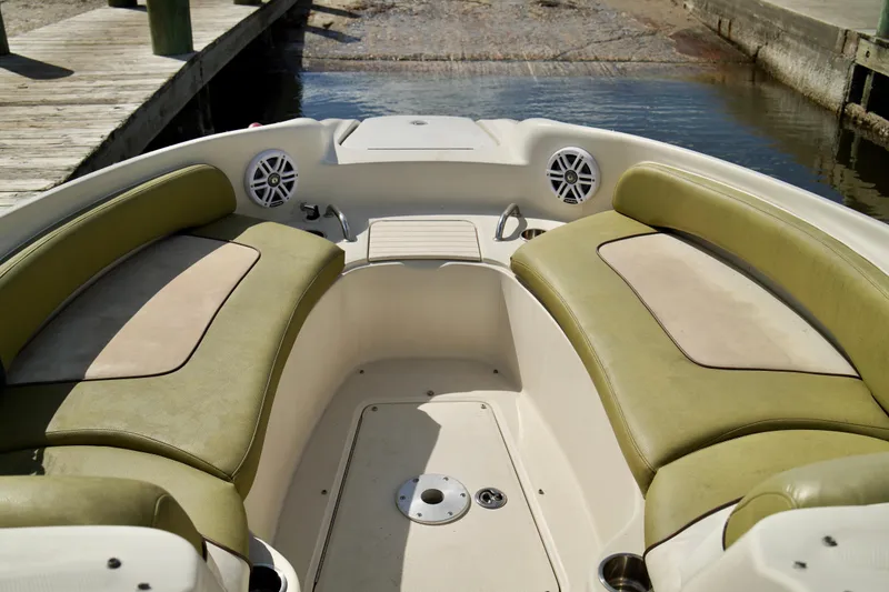 Slide: The Image of 2005 Sea Ray 240 Bow Rider interior with green seating, dockside view. - 6