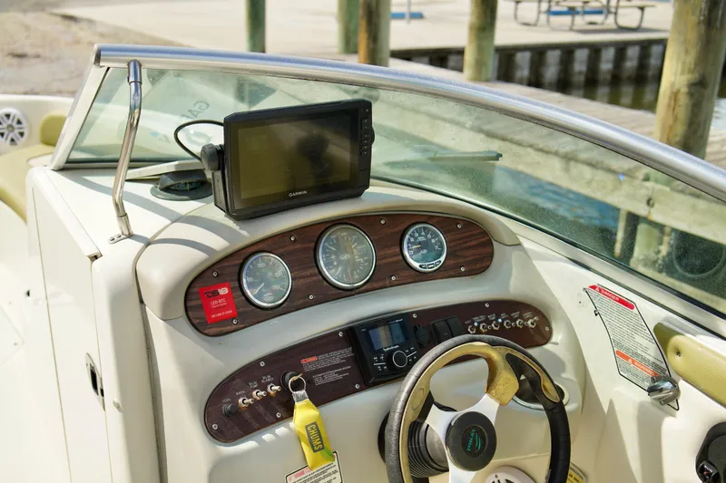 Slide: The Image of 2005 Sea Ray 240 Bow Rider dashboard with steering wheel and navigation system. - 8