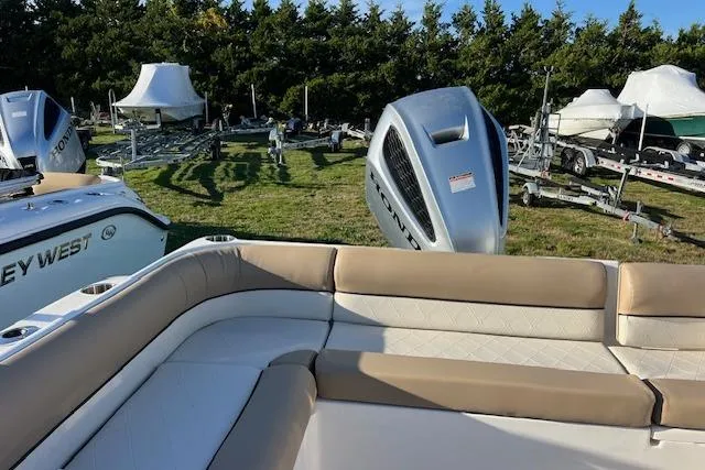Slide: The Image of 2019 Key West 239 DFS boat with seating, outboard motors, and trailers in a grassy area. - 10