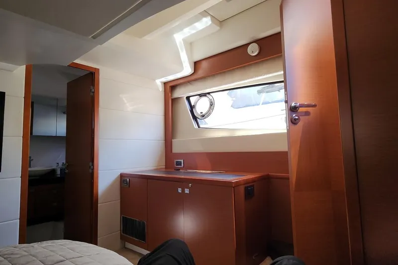 Slide: The Image of Interior cabin of 2016 Jeanneau Prestige 50 yacht with wooden furnishings and window. - 16