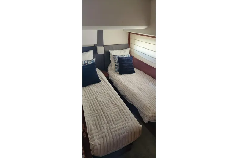 Slide: The Image of Twin beds in the 2016 Jeanneau Prestige 50 yacht cabin, featuring elegant bedding and decor. - 18