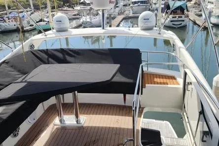 Slide: The Image of 2016 Jeanneau Prestige 50 yacht with covered seating area in marina. - 21