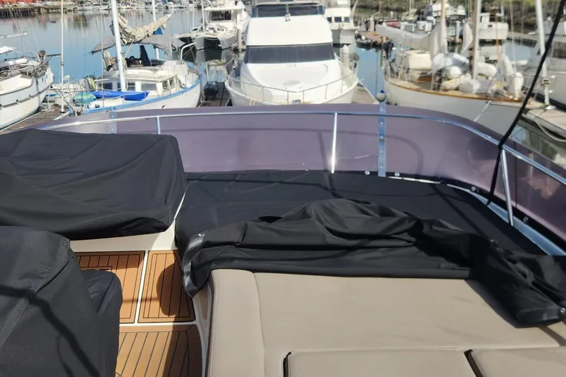 Slide: The Image of Jeanneau Prestige 50 yacht deck, 2016 model, docked at marina with covered seating. - 22