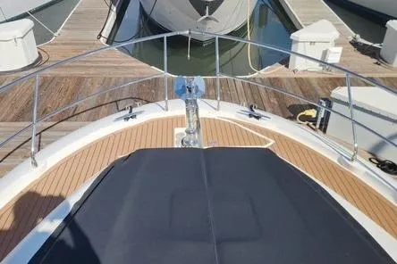 Slide: The Image of 2016 Jeanneau Prestige 50 yacht bow with teak deck and anchor at marina. - 26