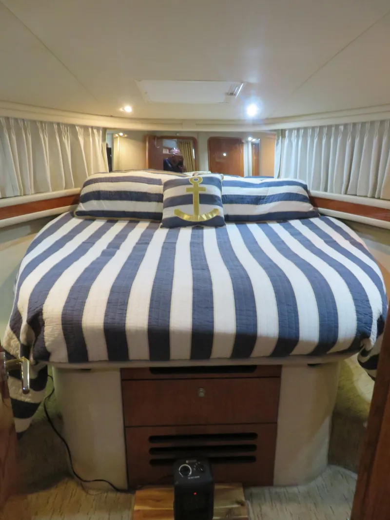 Slide: The Image of 1999 Sea Ray 480 DB yacht bedroom with striped bedding. - 20