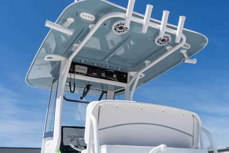 Slide: The Image of 2026 Sea Hunt Ultra 275 SE boat console with T-top and rod holders against blue sky. - 11