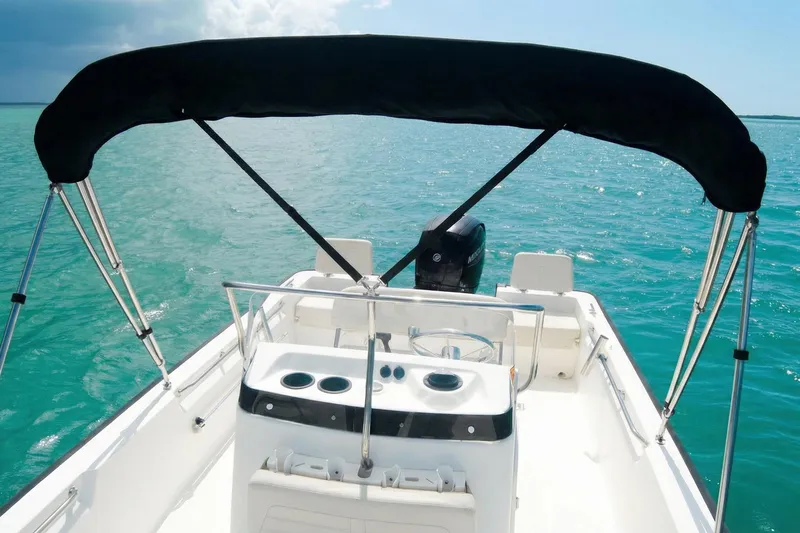 Slide: The Image of 2020 Boston Whaler 190 Montauk boat on water, featuring a Mercury engine and canopy. - 2