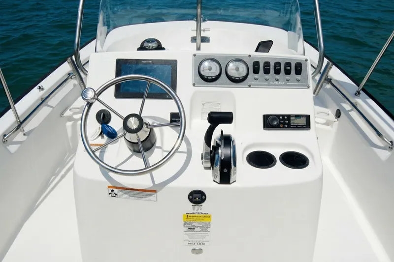 Slide: The Image of 2020 Boston Whaler 190 Montauk boat on trailer, parked near houses and trees. - 3