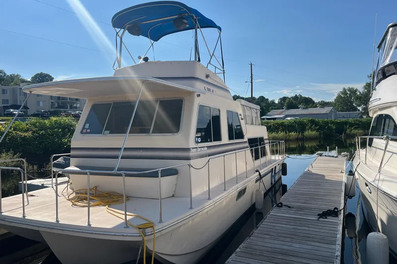 Slide: The Image of 1989 Holiday Mansion Super houseboat docked under clear blue sky. - 1