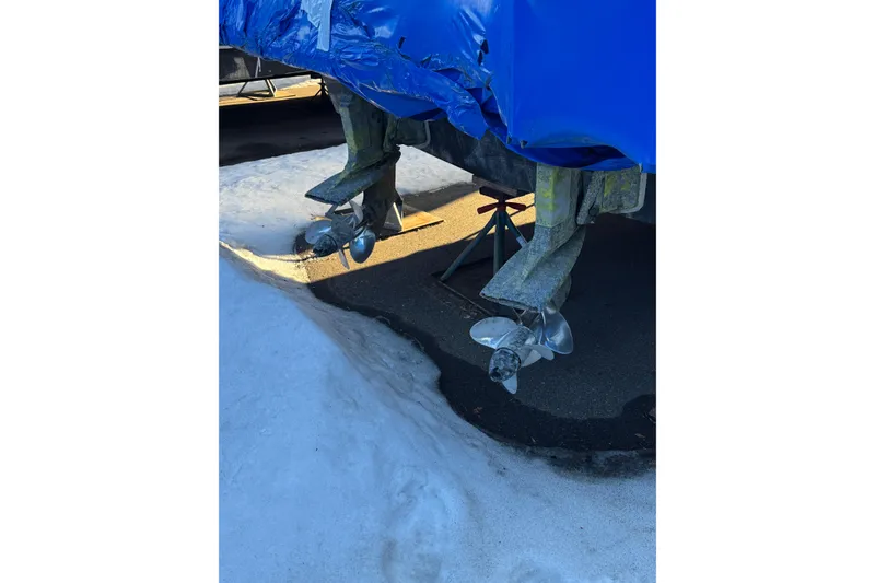 Slide: The Image of 1989 Holiday Mansion Super boat propellers, covered in blue tarp, on snowy ground. - 13