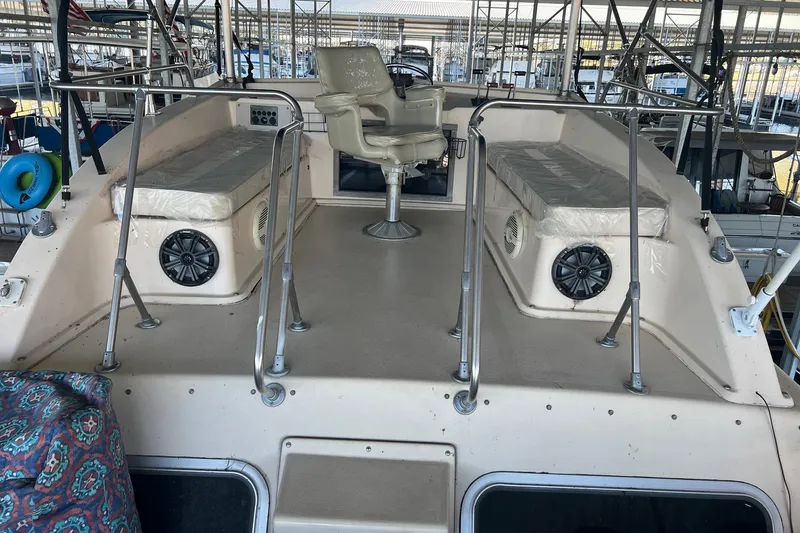 Slide: The Image of 1989 Holiday Mansion Super boat deck with seating and steering chair in marina. - 2