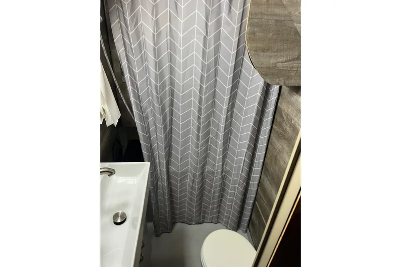 Slide: The Image of 1989 Holiday Mansion Super bathroom with shower curtain and compact sink. - 8