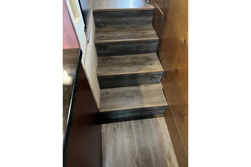 Slide: The Image of Staircase inside 1989 Holiday Mansion Super, featuring dark wood steps and paneling. - 9