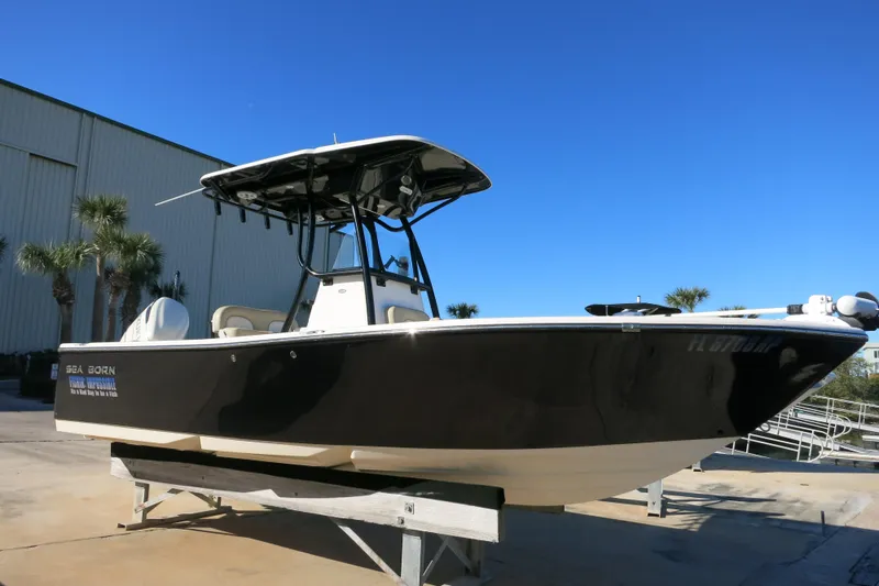 Slide: The Image of 2019 Sea Born LX22 Center Console boat on display, black hull, outdoor setting. - 3